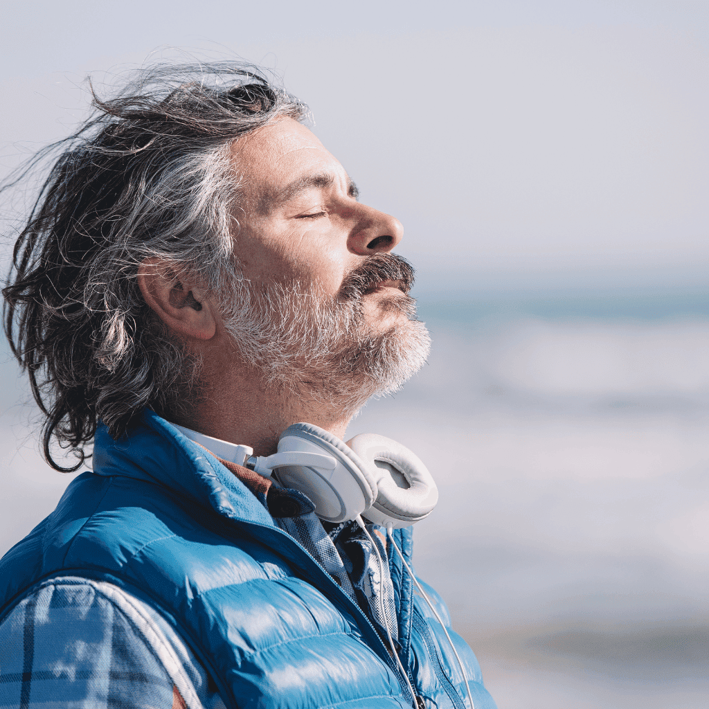 Man with headphones relaxing by the ocean