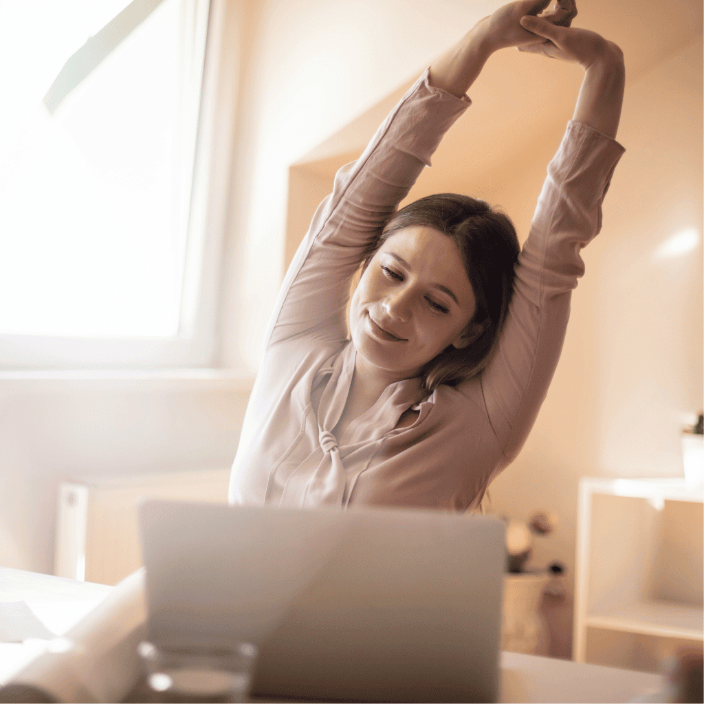 Woman stretching while sitting at her desk
