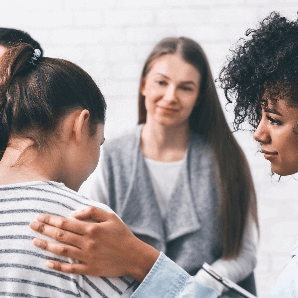 Woman comforting a girl in a group setting