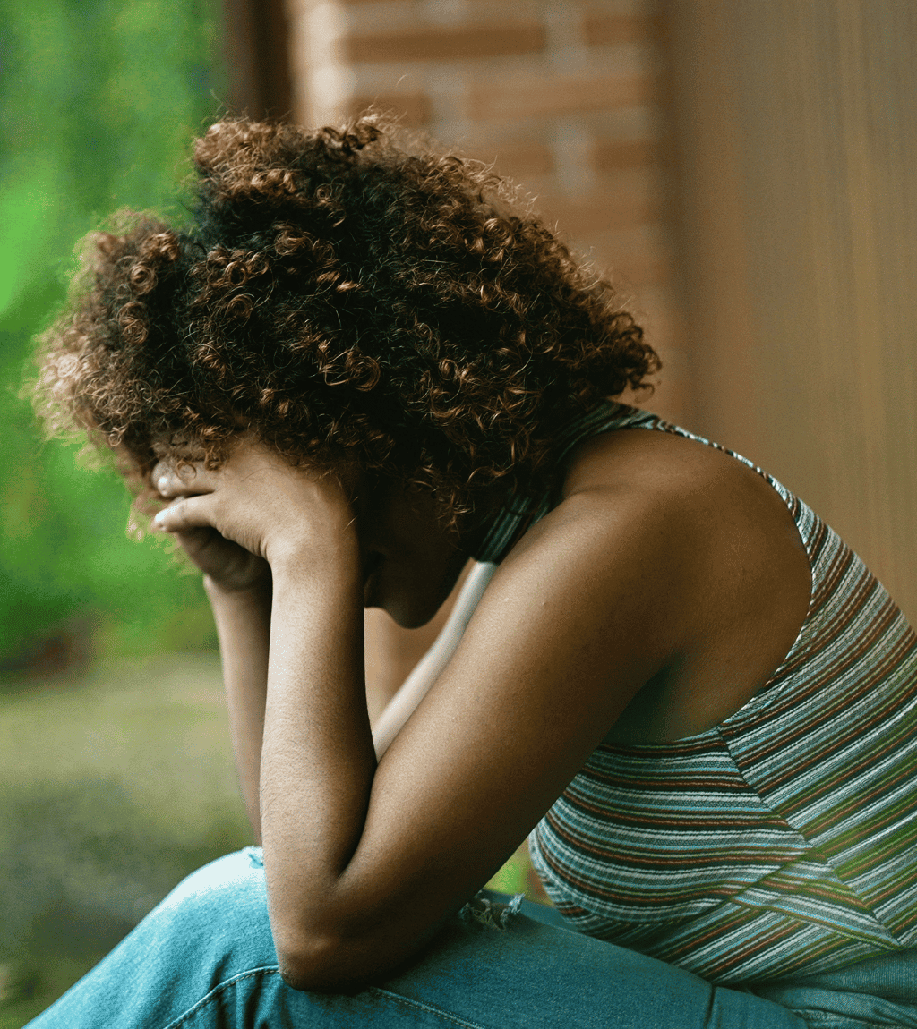 Person sitting with their head in their hands