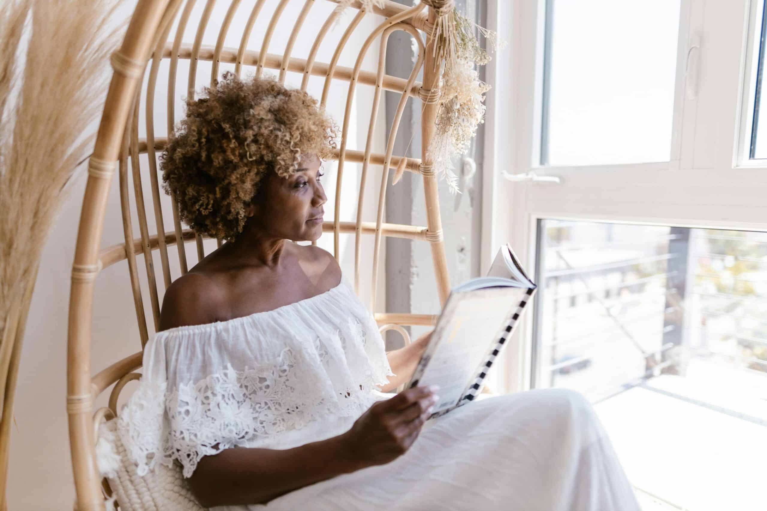 Woman sitting by window reclaiming peace after narcissist